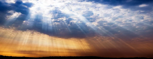 Rays of light shining into city, dramatic sunset © evilwata