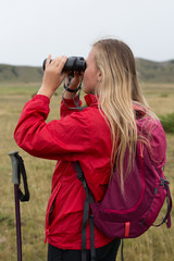 Woman Traveler with Backpack hiking in Mountains with beautiful