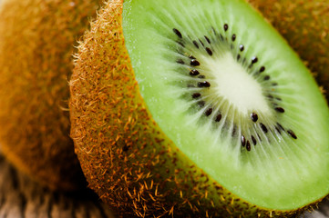 Some fresh Kiwi Fruits (selective focus) on an old wooden table, half of kiwi
