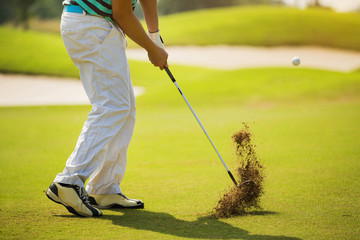 Golfer hitting ball with force. The grass distribution The blur
