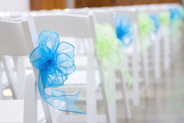 White Chairs with Blue and Green ribbons