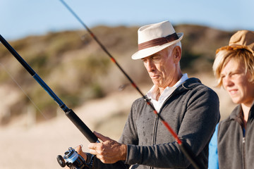 Senior man fishing with his grandson