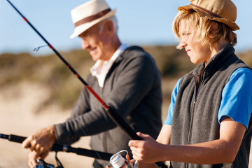 Senior man fishing with his grandson