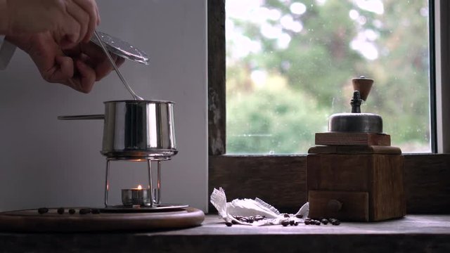rustic still life. preparing coffee. woman's hand mixing the hot water in the bucket
