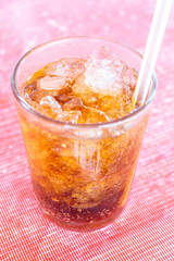 Coke or Pepsi and ice in glass.