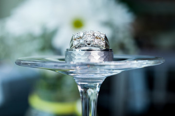 Obraz na płótnie Canvas Wedding rings on a wine glass