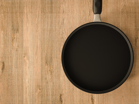 empty black pan on wooden table