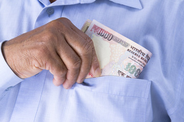 Man checking or counting Indian rupees in hand.