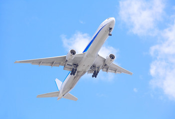 Fototapeta na wymiar Airplane taking off bottom view and blue sky