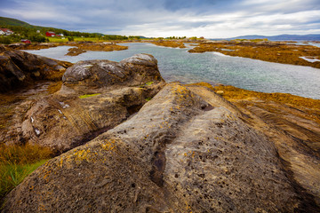 Fjord, rocky beach in cloudy weather, Norway