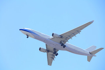 Fototapeta na wymiar Airplane taking off bottom view and blue sky