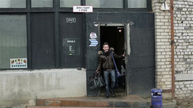 A group of people from six members is going out of the door of an industrial building.