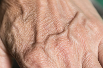 Naklejka premium closeup vein at hand of elder human wrinkled skin, white asian women.