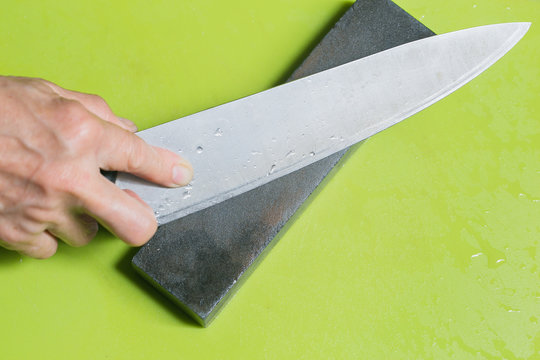 hand sharpening chopper with grindstone in the kitchen, kitchen knife. - Powered by Adobe