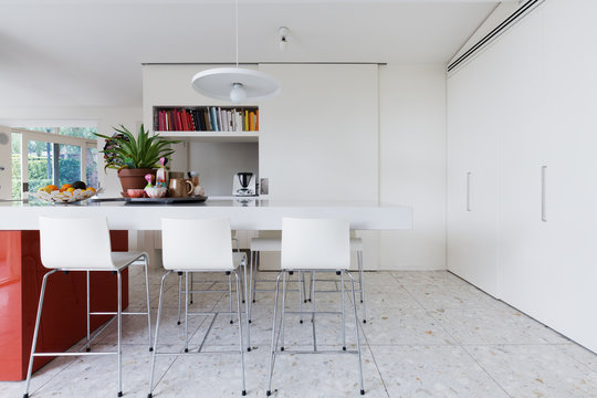 Clean crisp white modern kitchen island bench with high chairs
