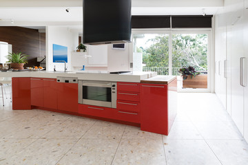 Orange red kitchen cabinets in island bench in modern luxury Aus