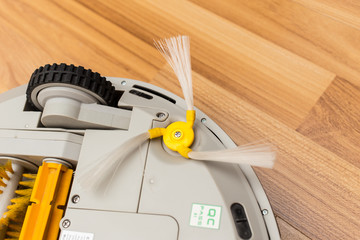 Robotic vacuum cleaner on wood parquet floor, Smart vacuum, new automate technology housework.