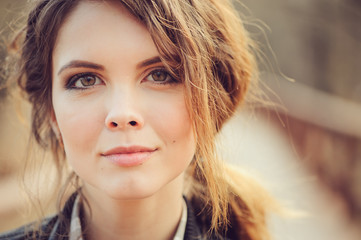 autumn outdoor portrait of young beautiful woman with natural makeup in leather jacket and plaid shirt, soft vintage toned