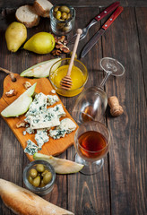 Blue cheese with honey, olive and pears on rustic table