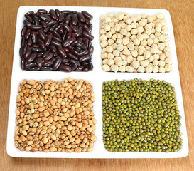 Four types of plant-based healthy food. These are kidney beans, garbanzo beans, black-eyed beans...