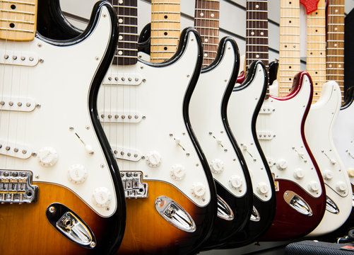 Many electric guitars body aligned in the store