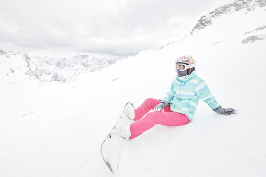 Young sitting woman with snowboard