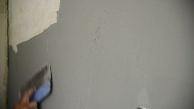 Plasterer plastering with a spatula wall