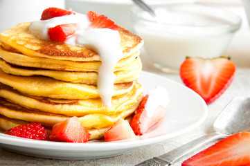 Pancekes with sour cream and strawberries for breakfast