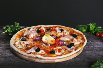 Pizza with red fish and mozzarella on the wooden. Top view.