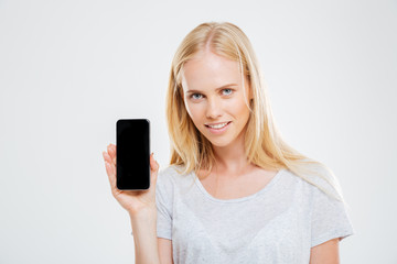 Fototapeta premium Smiling young woman showing blank smartphone screen