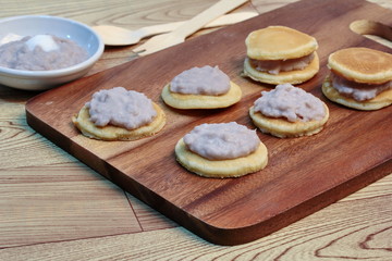 Mini pancake topped stirred taro on wood. Selective focus