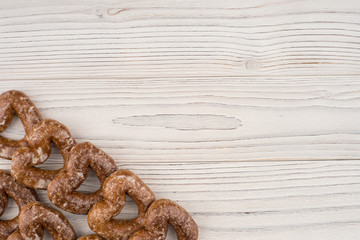 Gingerbread heart cookies on a wooden white background.