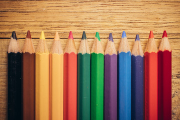 Crayons pencils on wooden background