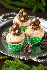 Christmas vanilla Cupcakes with chocolate buttercream, old wooden background, selective focus. Holiday concept