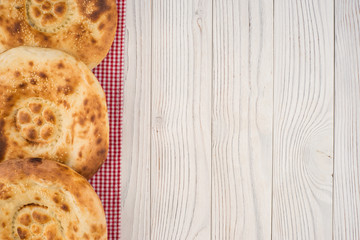 Uzbek bread on old white wooden table.