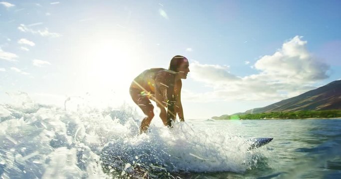 Beautiful surfer girl riding wave at sunset in slow motion