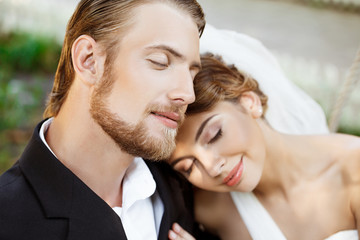 Young beautiful newlyweds smiling with closed eyes, enjoying.