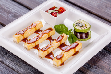 cheese sticks with sauce and vegetables