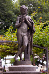 Naklejka premium Young naked statue playing the flute