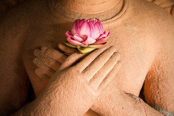 Lotus in the hands of sandstone Buddha.