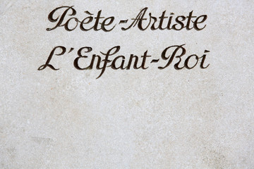 Inscription sur une pierre tombale : "Poète-Artiste, l'Enfant-Roi".
