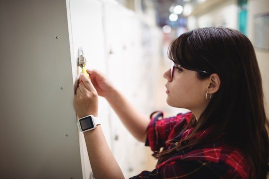 Female student locking her locker