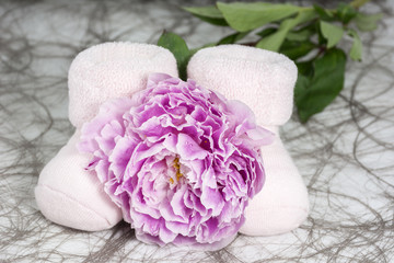 Pair of bootees for newborn girl with one peony with drops of water
