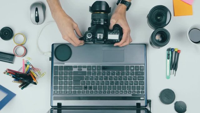 Above view. Photographer working at desk ina creative agency. 4K.
