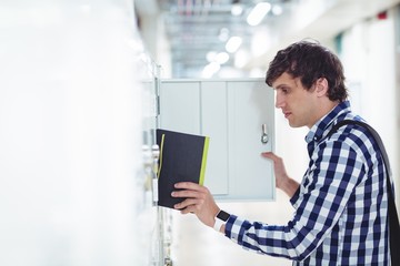 Student keeping his book in the locker