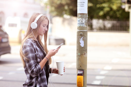 Teenager mit Handy und Kopfh&ouml;rer im Verkehr
