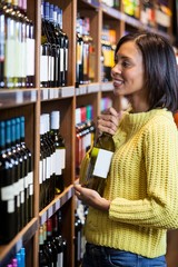 Woman selecting wine in grocery section