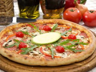 italian pizza on table with olive oil bottles, tomatoes and onion