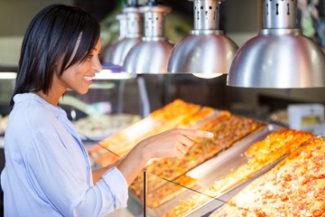 Excited woman pointing at snacks in disp