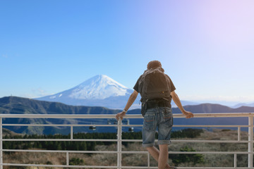 Naklejka premium Backpacker standing on the balcony and look at Mount Fuji in Japan.